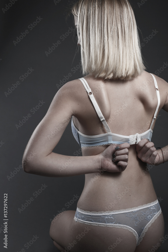 Belle femme blonde en sous-vêtement dégrafant son soutien gorge Stock Photo  | Adobe Stock