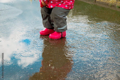 Fototapeta Naklejka Na Ścianę i Meble -  little girl play in water puddle