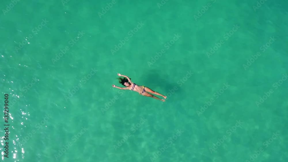 Beautiful young woman swimming, lying on a water surface in crystal clear sea. HD aerial slow motion shot. Thailand. Beautiful young woman swimming, lying on a water surface in crystal clear sea. HD aerial slow motion shot. Thailand.