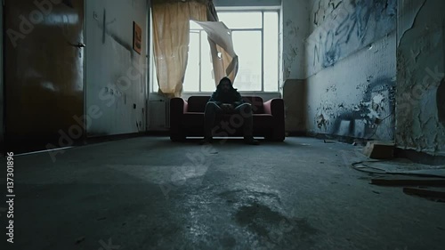 Angry hooded young man inside dark derelict ghetto building apartment,slowmo photo