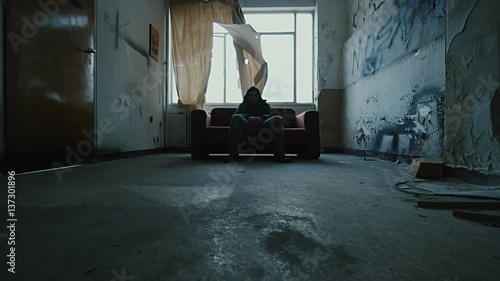 Angry hooded young man inside dark derelict ghetto building apartment,slowmo