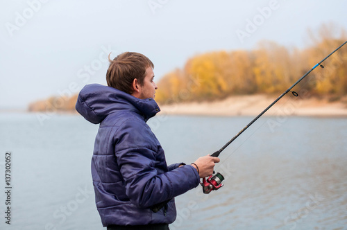 man holding a spinning, engaged in fishing on the river