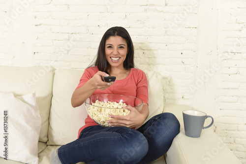 happy woman eating popcorn watching television at sofa couch happy excited enjoying movie