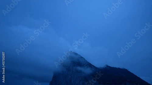 Dawn time-lapse of the Rock of Gibraltar with blue morning cloudy sky, UK. photo