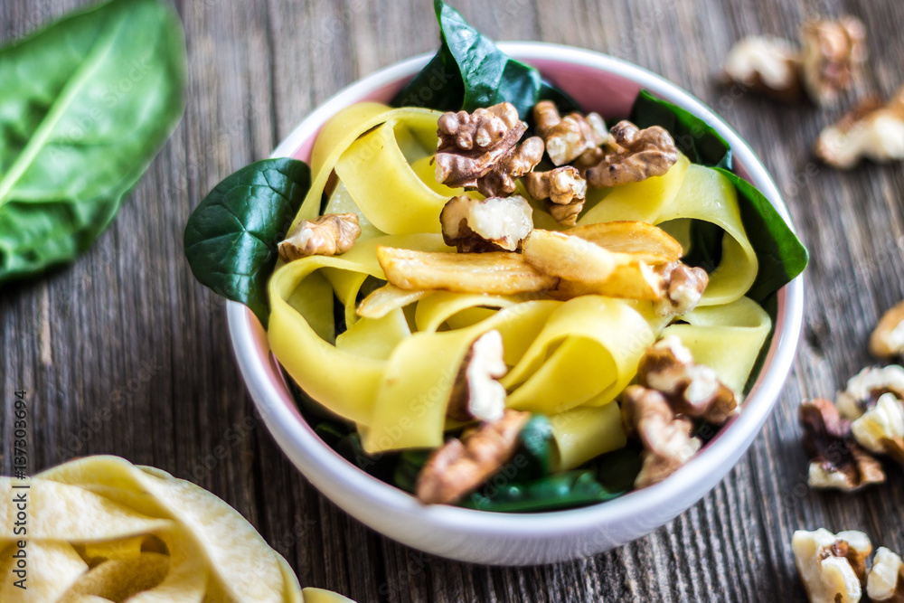 Pasta with Walnuts and Fresh Spinach Leaves on Wooden Background. Pasta with Walnuts and Fresh Spinach Leaves on Wooden Background.