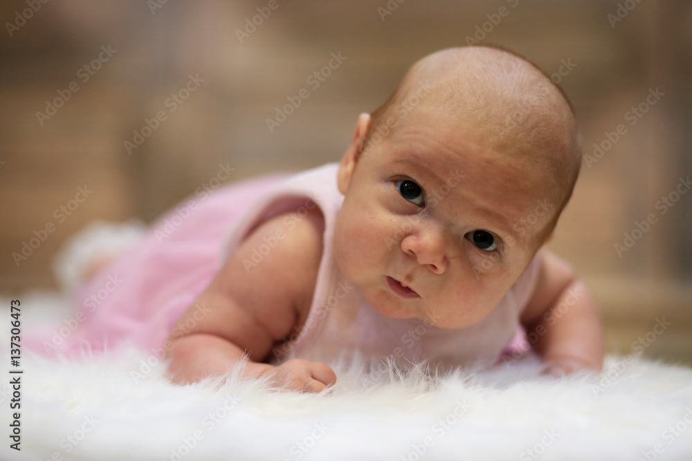 Newborn cute baby lying on white fur skin Newborn cute baby lying on white fur skin