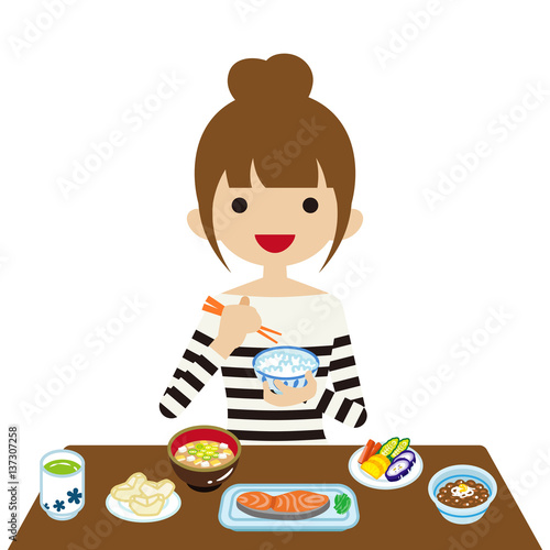 和食の朝食を食べる若い女性