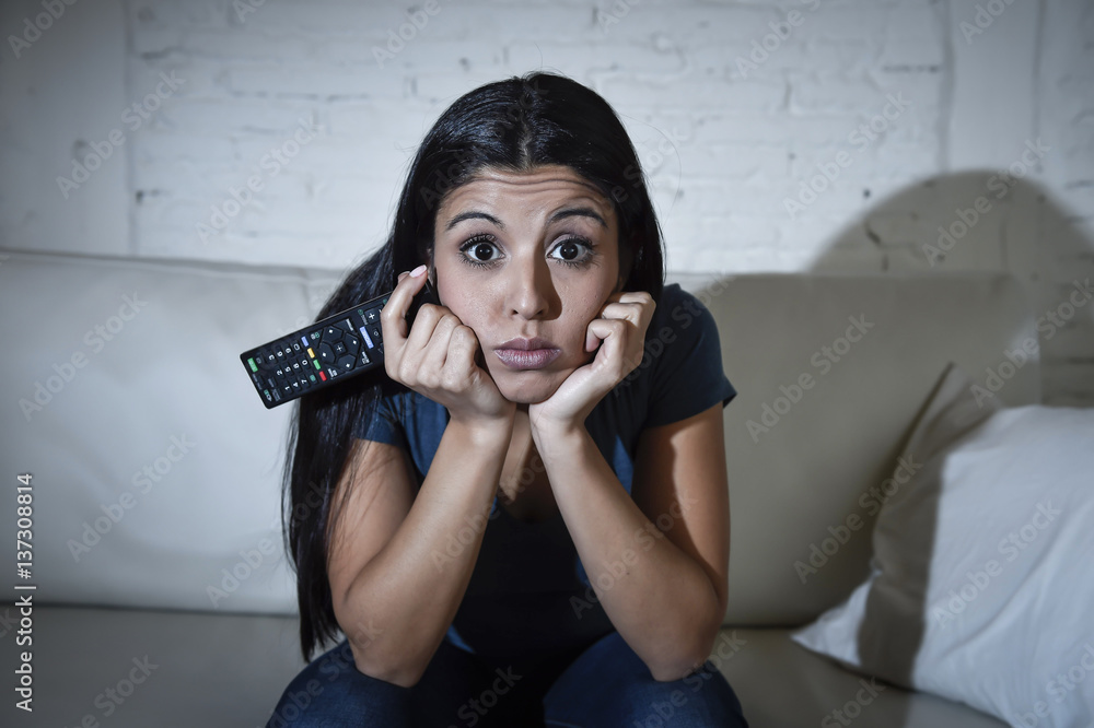 Naklejka premium woman at home sofa couch in living room watching television very concentrated and focused