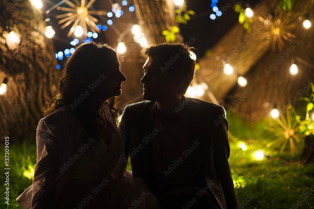 wedding couple in magical night forest decorated light garlands silhouette