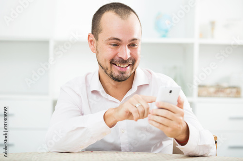 Positive young man with smartphone