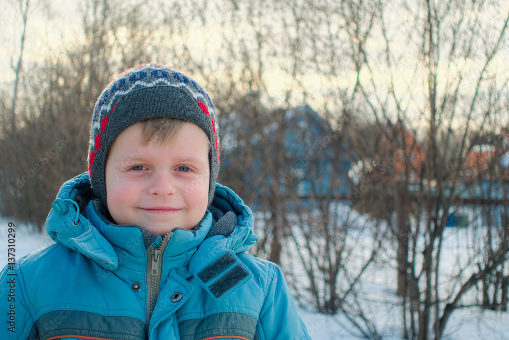 Little boy in warm jacket and the background of the rural landscape Little boy in warm jacket and the background of the rural landscape