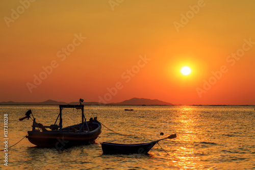 Silhouette Fishing boat with sun setting in background