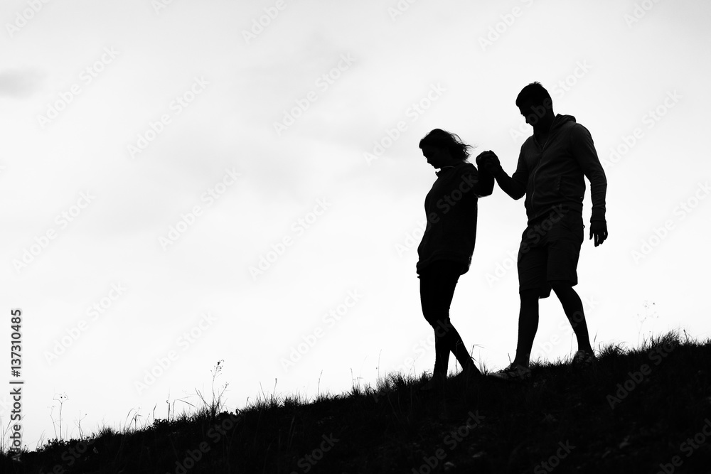 Сouple coming down the mountain holding hands