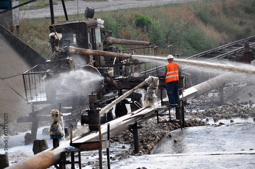 Workers sugar factory with water on piles of sugar beets served raw material for further processing in the shops