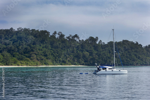 Excursion modern luxury motor boat catamaran near the coastline of beautiful lagoon with azure water at summer sunny day