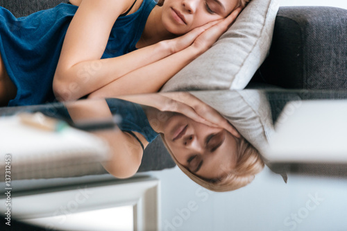 Exhausted lovely young woman lying and sleeping at home