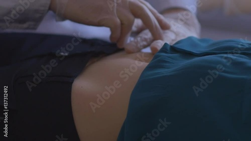doctor palpates the abdomen patient in his office