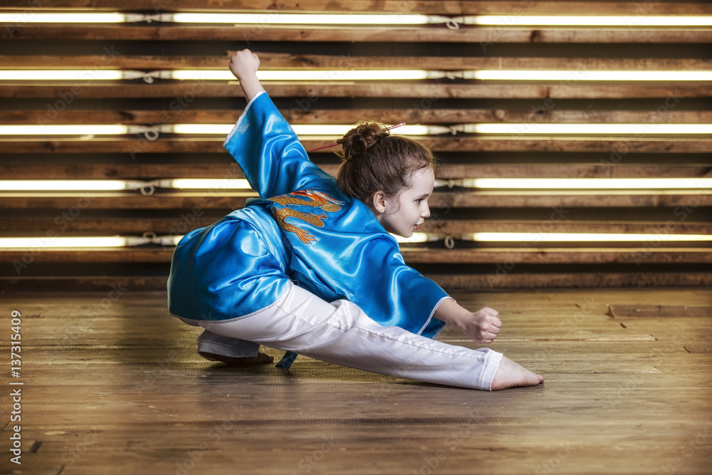 Pretty little girl in the room in sportswear for martial arts is Wushu  Stock Photo | Adobe Stock