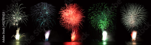 Set of five real fireworks on a black background, over water: red fireworks, fireworks blue, green, white fireworks.