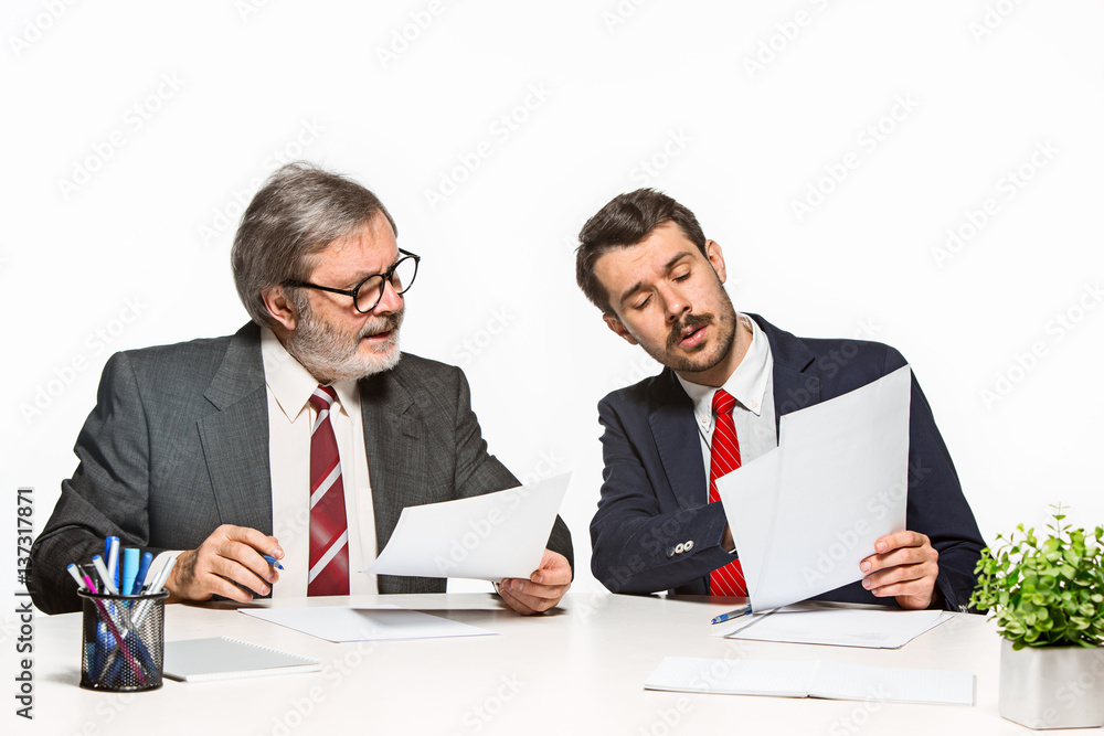 The two colleagues working together at office on white background. The two colleagues working together at office on white background.