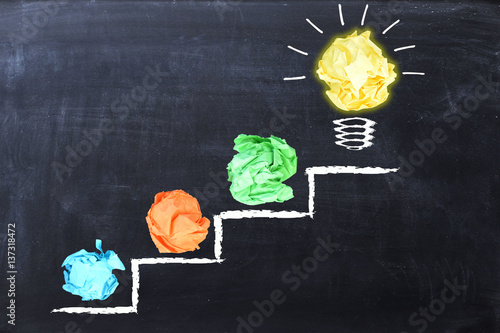 Canvas Print Evolving idea concept with colorful crumpled paper and light bulb on steps drawn