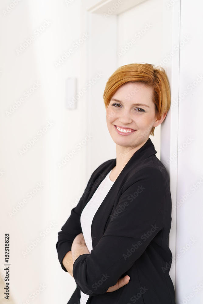 lächelnde frau im büro lehnt entspannt an der wand lächelnde frau im büro lehnt entspannt an der wand