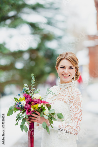 Close-up portrait of a bride with a big beautiful bridal bouquet