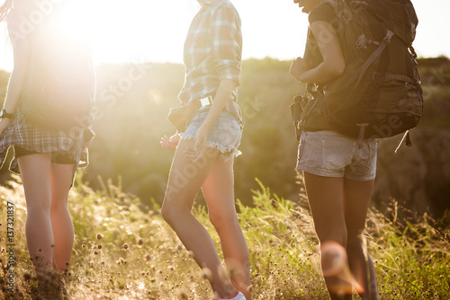 Young beautiful girls travelers walking in canyon at sunset.