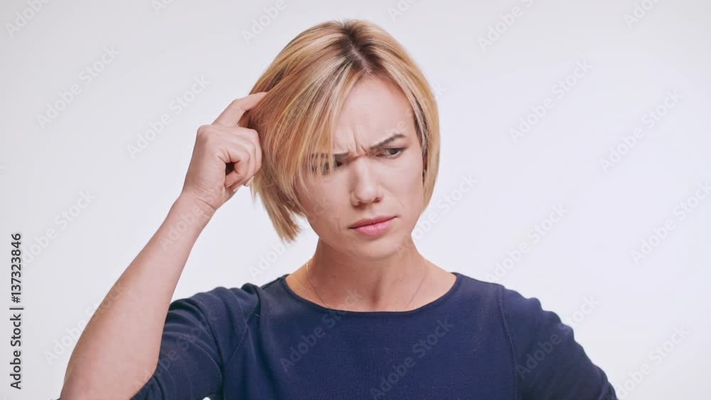 Thoughtful Caucasian middle-aged female with blonde hair standing on white background wearing blue sweatshirt on muse and then realising in slowmotion Thoughtful Caucasian middle-aged female with blonde hair standing on white background wearing blue sweatshirt on muse and then realising in slowmotion