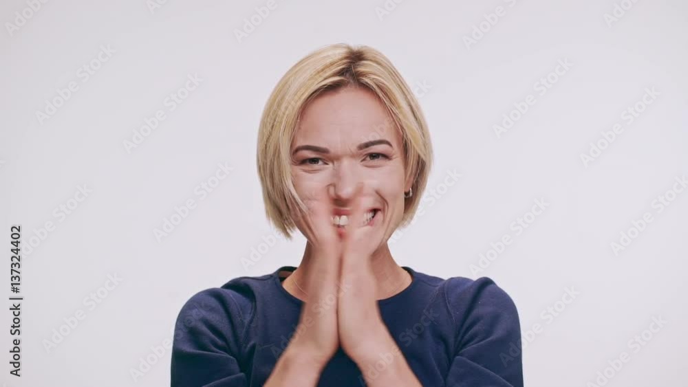 Joyful middle-aged Caucasian blonde female dancing laughing smiling showing ok on white background in slowmotion