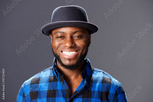 african man smiling with hat and plaid shirt