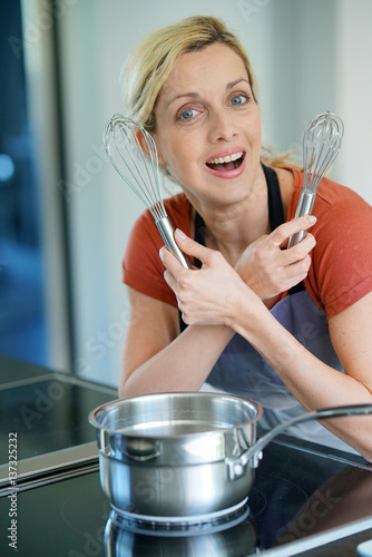 Portrait of woman in kitchen ready to cook pastry photo