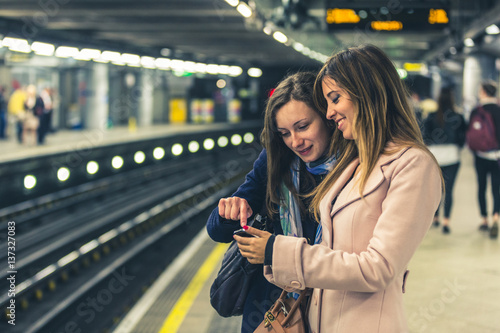 Canvas Print Two girls on the London underground waiting for the train.