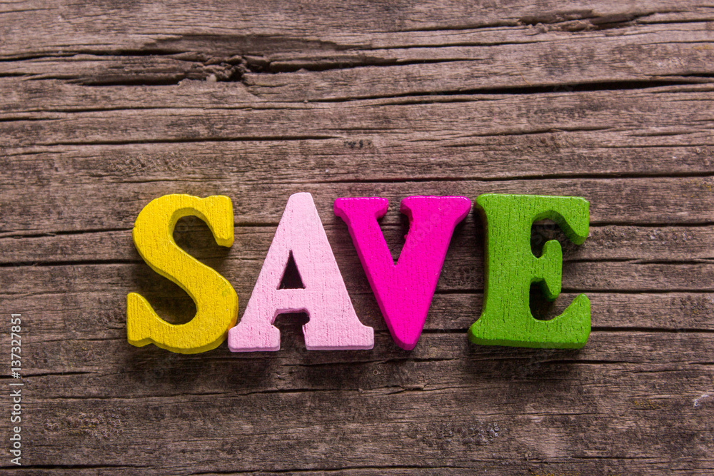 Fototapeta premium save word made from colored wooden letters on an old table. Concept