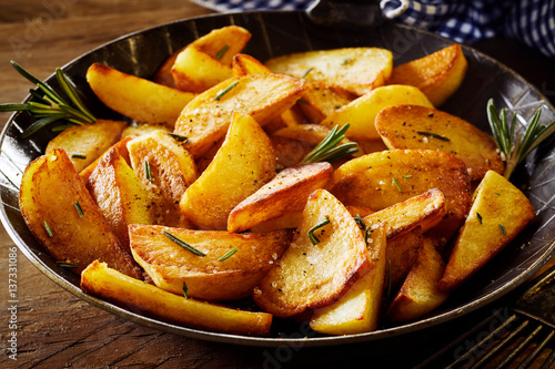 Photography Tasty crispy fried wedges of potato with rosemary