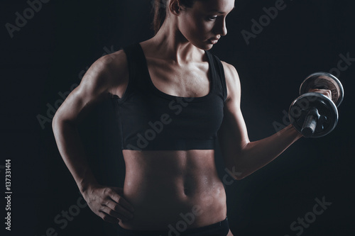  Strong fit woman exercising with dumbbells