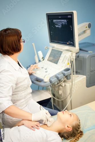 ultrasound device, the doctor makes examination of the thyroid gland in girls