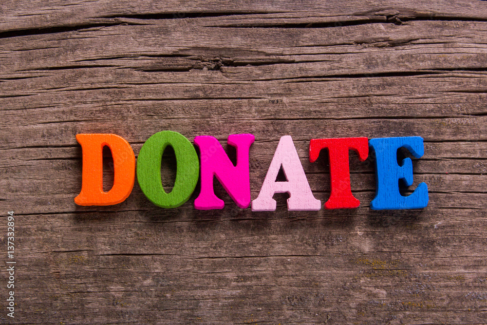 Fototapeta premium donate word made from colored wooden letters on an old table. Concept