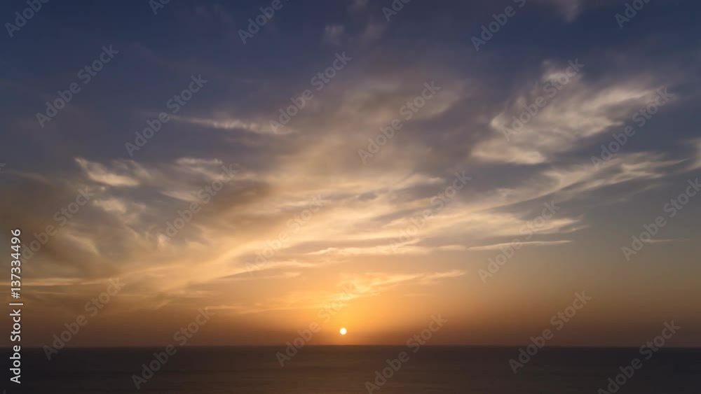 4k time lapse of clouds crossing the amazing sky over the sea or ocean at sunset. transition from day to night. The clouds cross slowly from left to right colored yellow orange purple blue 4k time lapse of clouds crossing the amazing sky over the sea or ocean at sunset. transition from day to night. The clouds cross slowly from left to right colored yellow orange purple blue