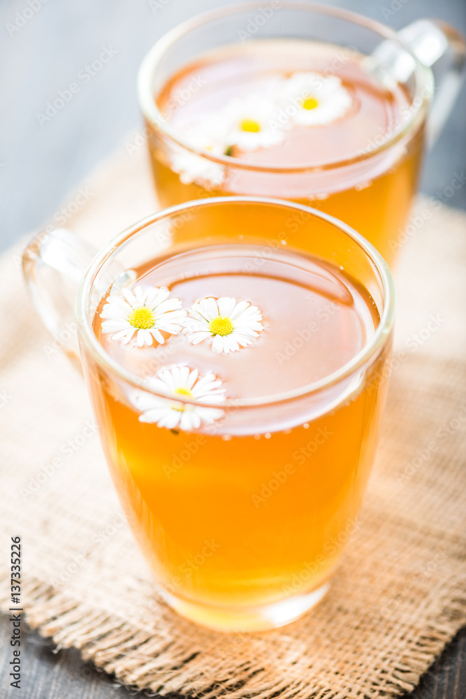 chamomile tea in a glass cup on wooden background chamomile tea in a glass cup on wooden background