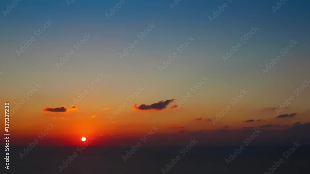 time lapse of clouds crossing the amazing sky over the sea or ocean at sunset. transition from day to night. The clouds cross slowly from left to right colored yellow orange purple blue time lapse of clouds crossing the amazing sky over the sea or ocean at sunset. transition from day to night. The clouds cross slowly from left to right colored yellow orange purple blue