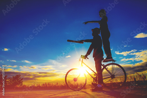 Silhouettes couples and bicycle on sunset sky couples concept .