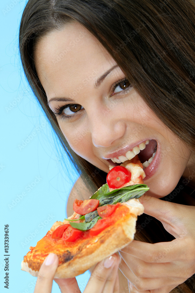 Young woman eating a pizza at the pool on holiday