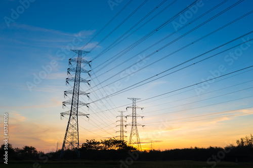 Silhouette high voltage electricity pylon on sunrise background