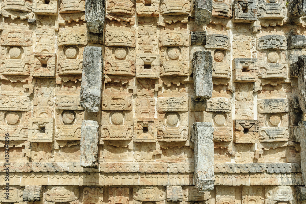 large masks of the Mayan god Chaac in the front of the palace of the masks or Codz Poop in the archaeological Kabah enclosure in Yucatan, Mexico.