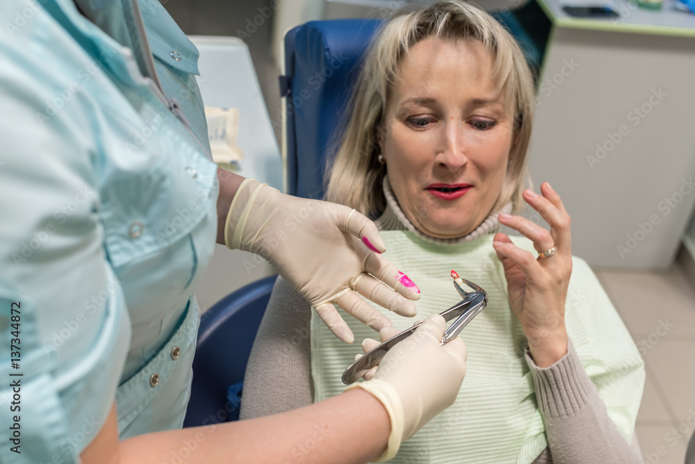 dentist removes the tooth patient at the dental clinic dentist removes the tooth patient at the dental clinic