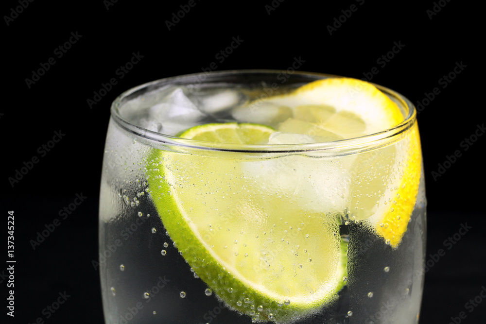 Mineral water in the glass with lime and lemon slices Mineral water in the glass with lime and lemon slices
