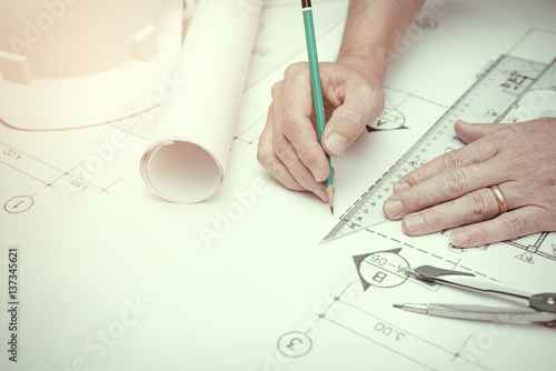 Civil engineer tools during worked at home office with white safety helmet ,divider,ruler and blue print..