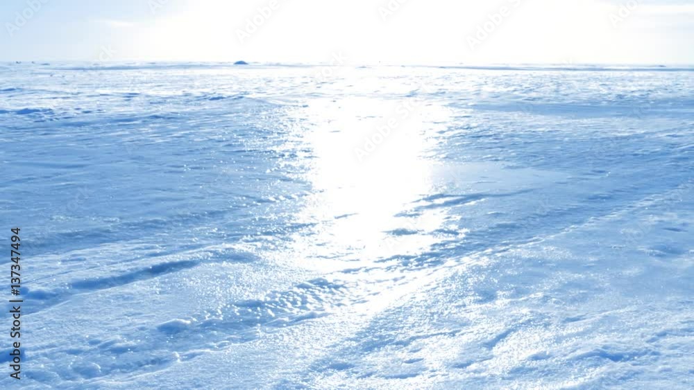 Frozen winter sea covered with snow, ice and crusted snow, sunshine. Slow pan. Frozen winter sea covered with snow, ice and crusted snow, sunshine. Slow pan.