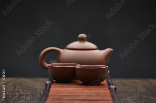 Traditional tea ceremony accessories, teapot and teacup with wooden background photo